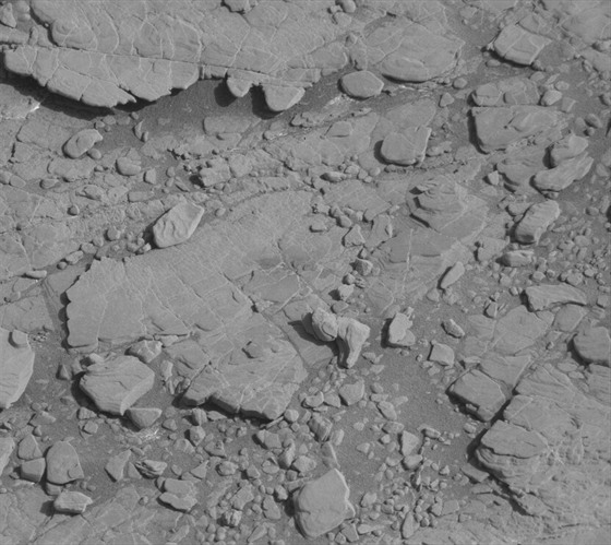 Snímek okolí marsovského roveru Curiosity, který zhruba uprostřed ukazuje útvar...