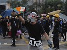 Demonstrant drící cihlu pi konfrontaci s policií. (5.8. 2019, Hongkong)