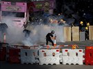 Demonstranti reagují na slzný plyn, který vypálila policie. (5.8. 2019)