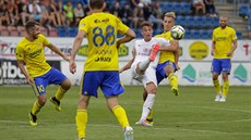 Zlíntí fotbalisté (ve lutém) stíhají soupee bhem utkání v Uherském Hraditi.