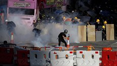 Demonstranti reagují na slzný plyn, který vypálila policie. (5.8. 2019)