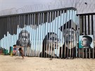 Jiní stranu hraniní zdi mezi USA a Mexikem zdobí portréty nkolika lidí,...