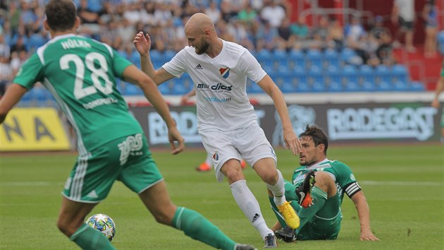 Tom Smola (Bank Ostrava) vede m, za nm skluzuje kapitn Bohemians Josef Jindiek.