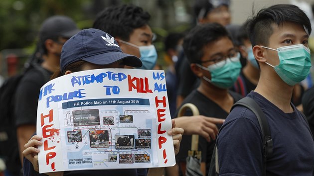 Demonstrantka drží v ruce ceduli s nápisem: „Hongkongská policie se nás všechny pokusila zabít. Pomoc!“. (17. srpna 2019)