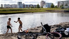Chlapci si hrají u řeky Kudma v ruském Severodvinsku. (24. července 2019)