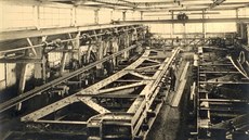 Historická fotografie zachycující výrobu a montáž mostu v železárnách...