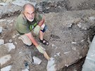 Archeolog Jiří Klsák čistí zbytky základů původního gotického kostela z 15....