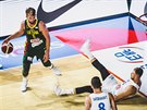 eský basketbalista Patrik Auda (vpravo) padá po souboji s Domantasem Sabonisem...