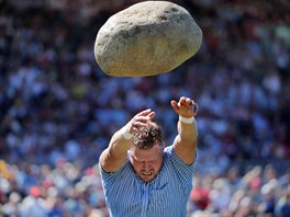 VÝCARSKÝ SPORT. Martin Jakober háe kamenem váícím 83.5 kilogramu bhem...