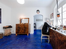 Specifická modrá podlaha z betonové strky se rozlévá skrz vechny prostory,...