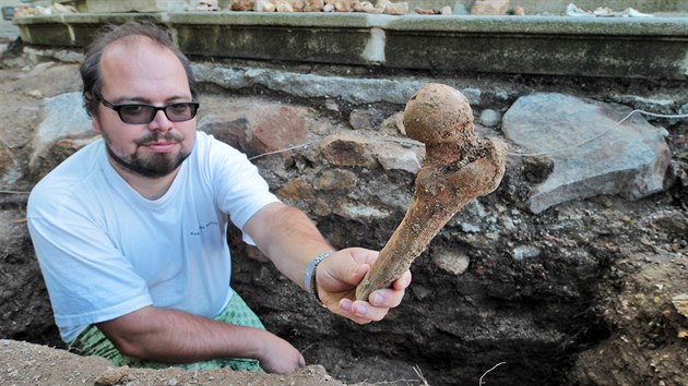 Archeolog Jan Tajer s jednou z kost, kter nalezli pi itn zklad vstupnho schodit ke karlovarskmu kostelu z 18. stolet.