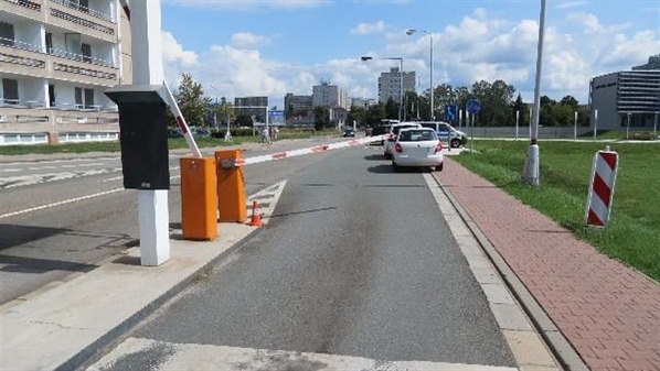 Řidič poškodil závoru u výjezdu z nemocnice v Hradci Králové i dvě zaparkovaná auta (16. 8. 2019).