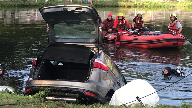 Hasiči museli v Hradišťku na Praze-západ lovit auto, které po proražení zábradlí sjelo do rybníka (21.8.2019)