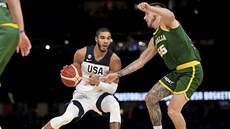 Americký basketbalista Jayson Tatum se snaí obejít Mitche Creeka z Austrálie.