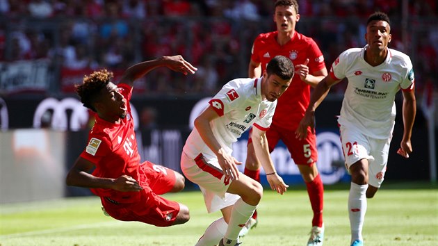 Kingsley Coman z Bayernu Mnichov (vlevo) pad na trvnk po stetu s Aaronem Martinem z Mohue.