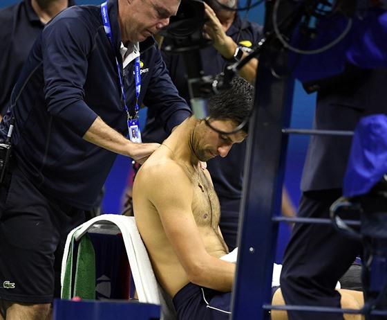 Srb Novak Djokovi si nechává oetit zranné rameno bhem osmifinále US Open.