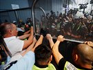 Letitní ochranka drí bránu, aby se demonstranti v Hongkongu nedostali na...