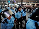 Jednotky poádkové policie procházejí letitm v Hongkongu, kde protestují...