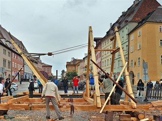 Tesaři na náměstí v Chebu sestavují a vztyčují pomocí bidla a kladkostroje...