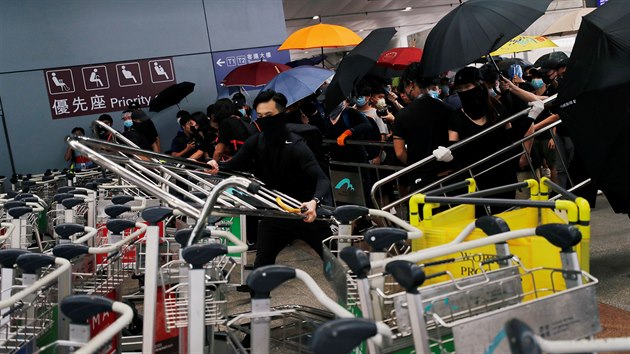 Demonstranti v Hongkongu vyuvaj ke stavb barikd i vozky na zavazadla, aby zamezili vstupu na letit. (1. z 2019)