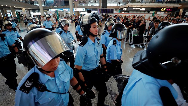 Jednotky podkov policie prochzej letitm v Hongkongu, kde protestuj protivldn demonstranti. (1. z 2019)