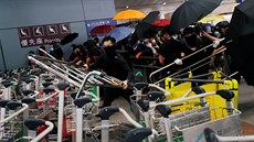 Demonstranti v Hongkongu vyuívají ke stavb barikád i vozíky na zavazadla, aby...