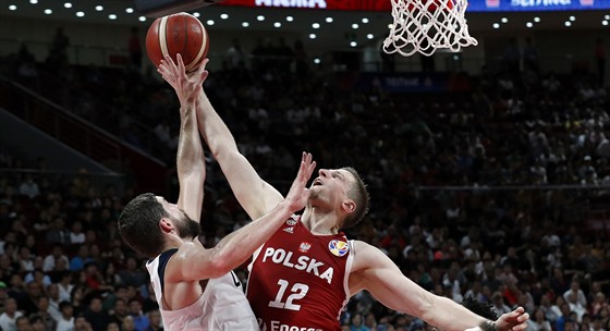 Polský basketbalista Adam Waczyski zakonuje v utkání proti USA kolem Joea...