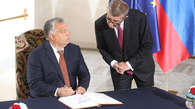 Maarsk premir Viktor Orbn se podepisuje do pamtn knihy ped jednnm V4 na Hrad. Vpravo esk premir Andrej Babi. (12. z 2019)