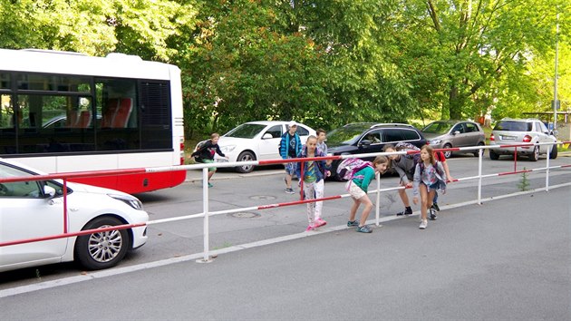 e U základní školy v pražských Hodkovičkách přebíhají děti ulici mezi auty, která přivážejí jejich spolužáky.