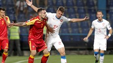 ernohorský fotbalista Marko Veovi si kryje balon ped eským reprezentantem...