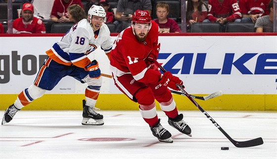 Obránce Detroitu Filip Hronek u puku v duelu s NY Islanders, stíhá ho Anthony...