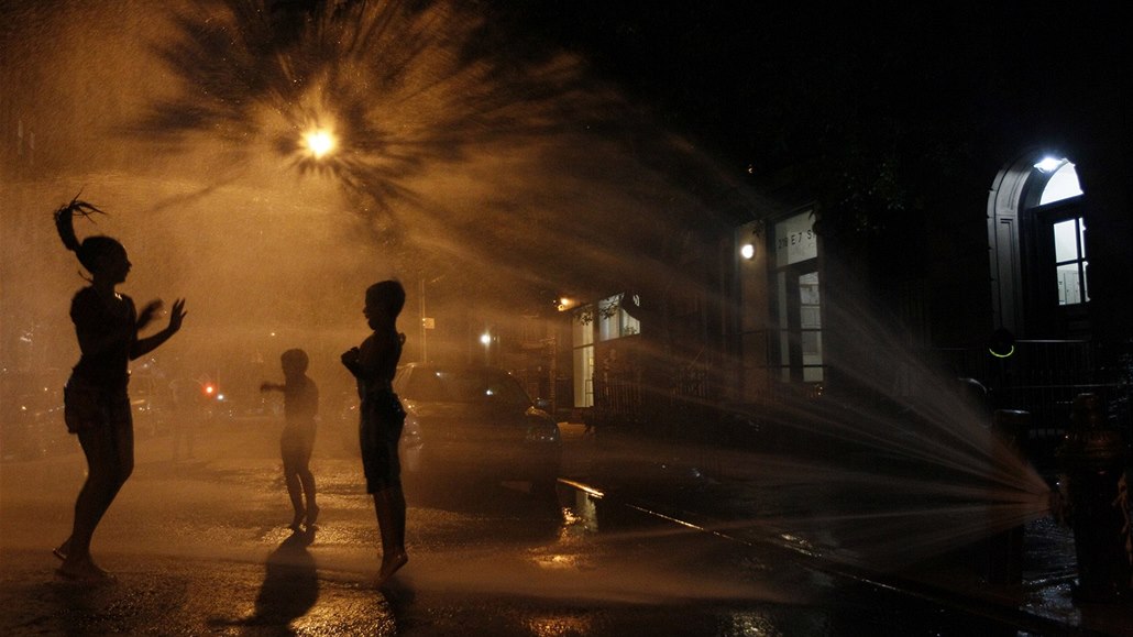 Hispánské děti dovádí u otevřeného hydrantu na Manhattanu. Ulice New Yorku se v...
