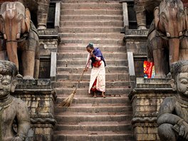 POŘÁDEK PŘED CHRÁMEM. Žena zametá schodiště nepálského chrámu Nyatapola.