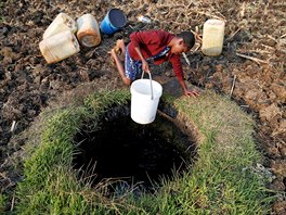 VÝPRAVA PRO VODU. Žena vytahuje kbelík s vodou ze studny v zimbabwském městě...