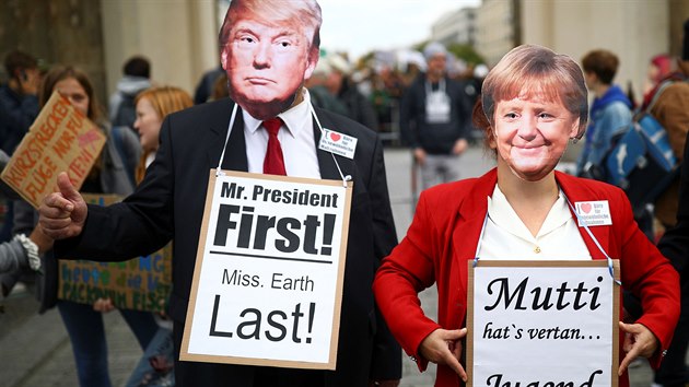 Berlnt demonstranti v maskch Donalda Trumpa a Angely Merkelov (20. z 2019)