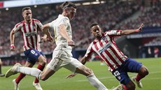 Renan Lodi z Atletica Madrid skáče do střely Garetha Balea z Madridu.