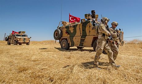 Amerití vojáci procházejí kolem tureckých obrnnc bhem spolené hlídky v...
