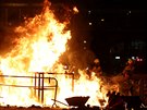 Hasii se snaí uhasit ohe zapálený demonstranty. (4. íjna 2019)