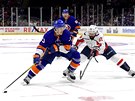 Mathew Barzal z NY Islanders u puku, brání ho Radko Gudas z Washingtonu.