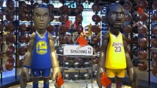 Sošky Stephena Curryho (vlevo) a LeBrona Jamese u vchodu pekingského obchodu NBA