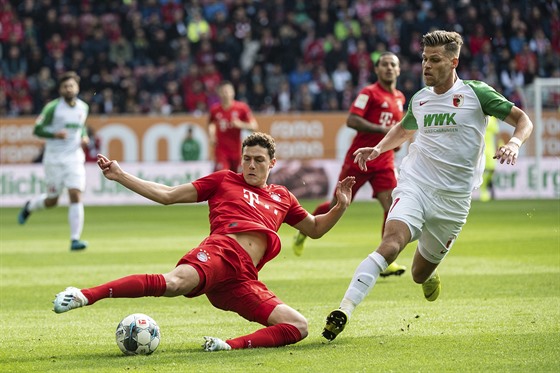 Benjamin Pavard (vlevo) z Bayernu Mnichov hraje balon, stíhá jej Florian...