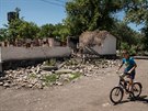 Chlapec projídí na kole kolem zniené budovy v doncké vesnici Novotoshkivske....
