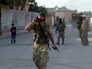Syrští povstalci procházejí městem Tal Abjád na kurdském severu Sýrie poté, co...