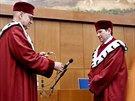 Nový rektor Masarykovy univerzity Martin Bare (vpravo) pebírá etz od svého...