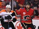 Michael Frolík (vpravo) z Calgary te hru, napadá ho Travis Sanheim z...