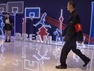 len ochranky prochází kolem neonové expozice v Pekingu vnované basketbalu.