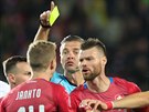 Slovinský sudí Damir Skomina udluje v utkání esko - Anglie lutou kartu...