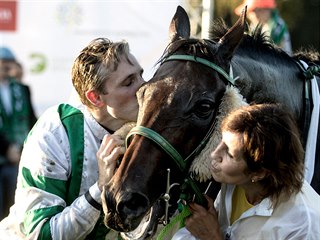 Žokej Josef Bartoš a trenérka Pavla Váňová odměňují hnědáka Theophilose za...