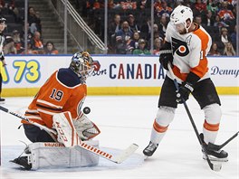 Útočník Sean Couturier z Philadelphia Flyers se snaží překonat Mikka Koskinena...