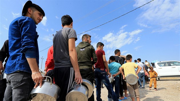 Syrsk rodiny, kter byly vyhnny ze svch domov, stoj ve front na jdlo v...